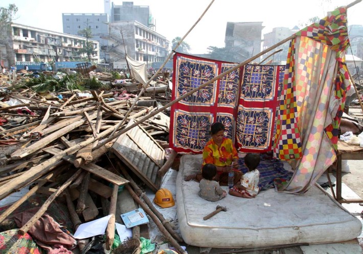 Former residents of the Borei Keila complex sit in a makeshift tent a day after being evicted in Phnom Penh